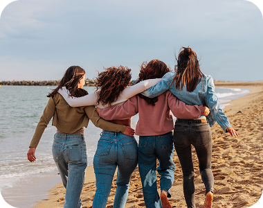 Four friends walking on the beach